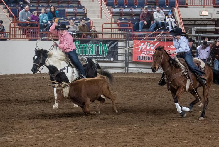 Two riders participating in team roping at PA Farm Show